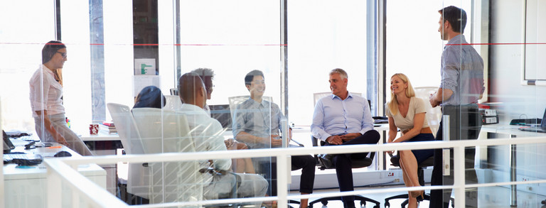 six people sitting together in a bright room are facing each other